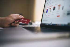 image of person holding plastic card on the computer